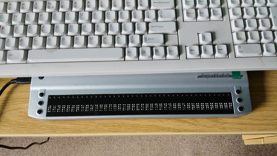 [Image of a keyboard sitting half ontop of a braille display]